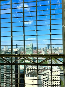 An architect reviewing blueprints in front of a large window with a city view.