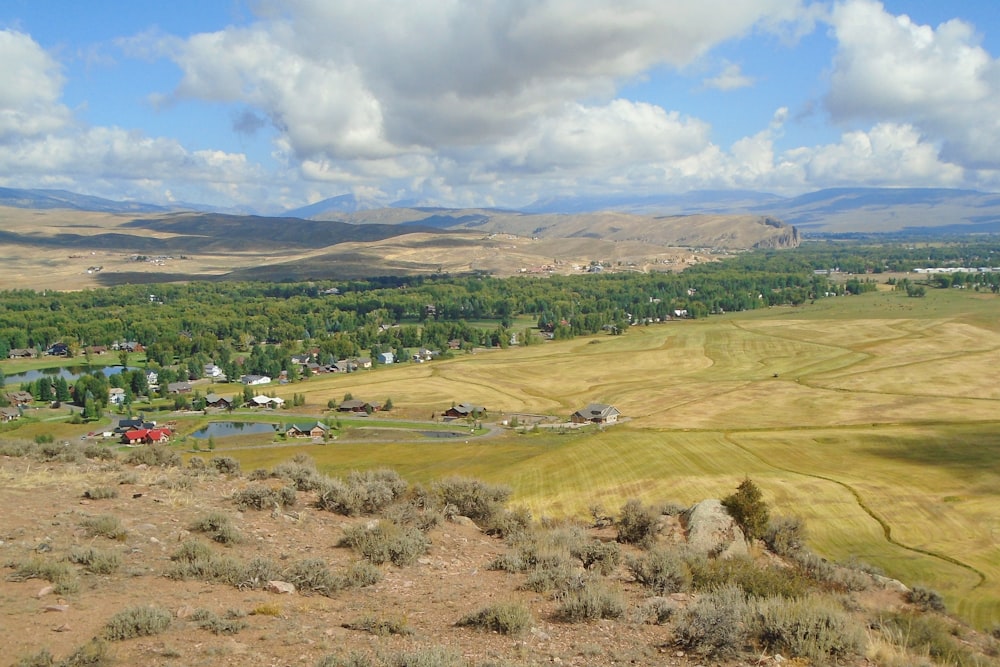 a large open field with a small town in the distance