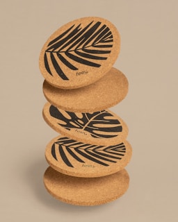 Round cork coaster featuring a detailed engraved logo