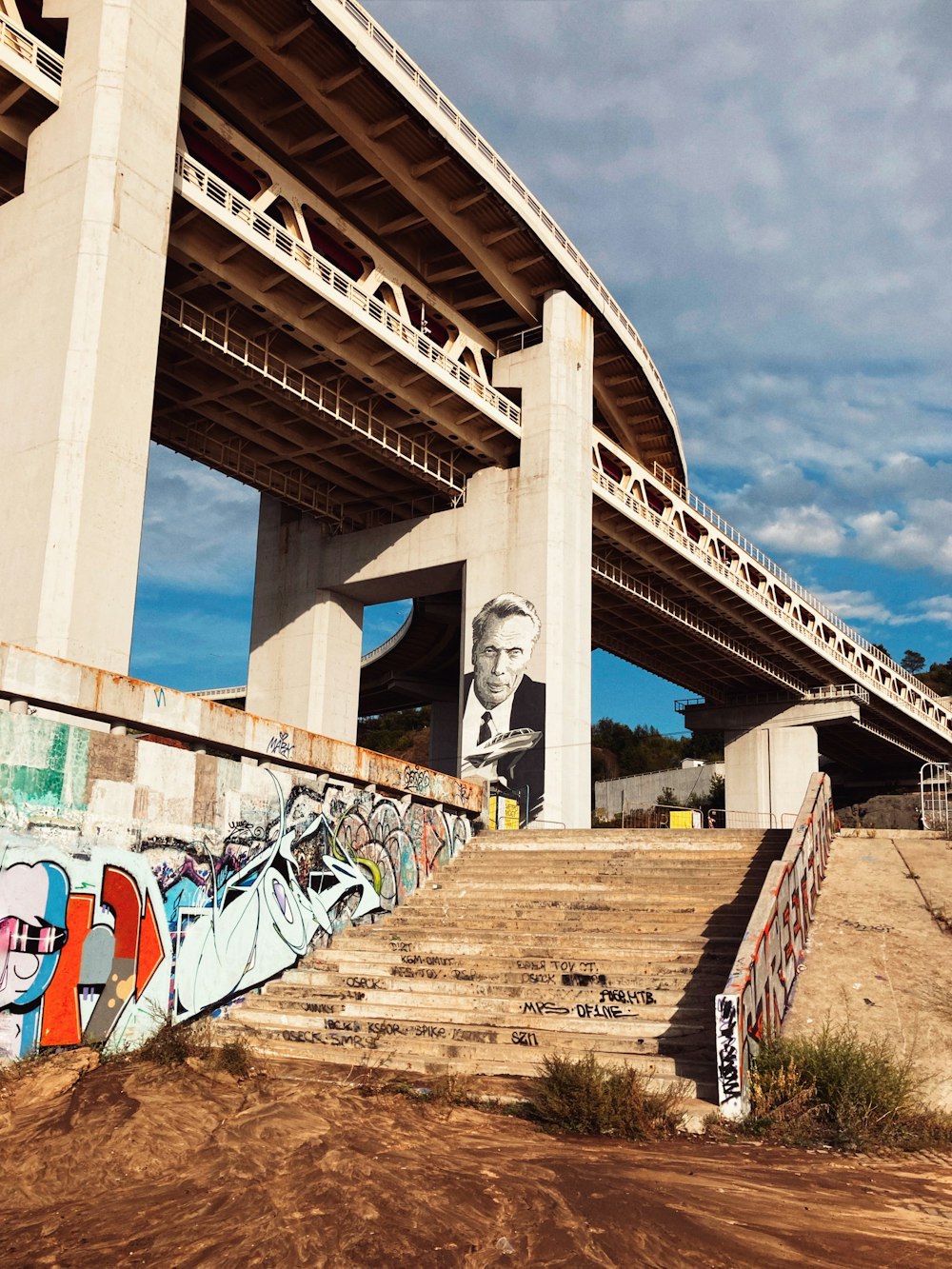 ein großes Wandgemälde eines Mannes an der Seite einer Brücke
