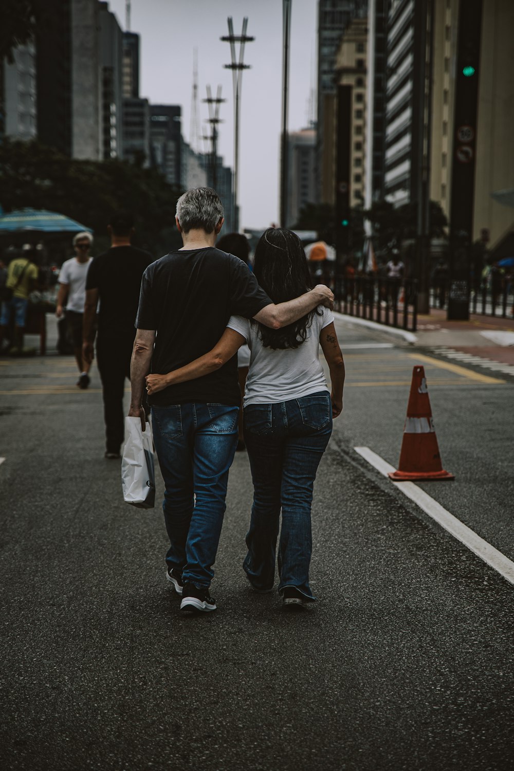 a couple of people walking down a street