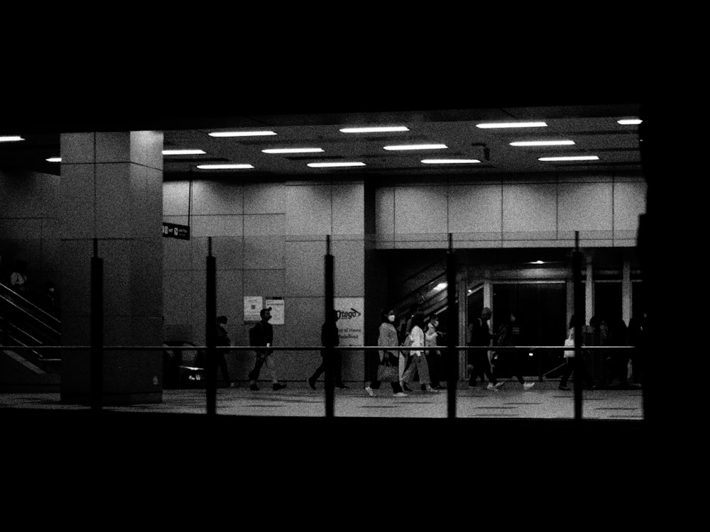 a black and white photo of people entering a building