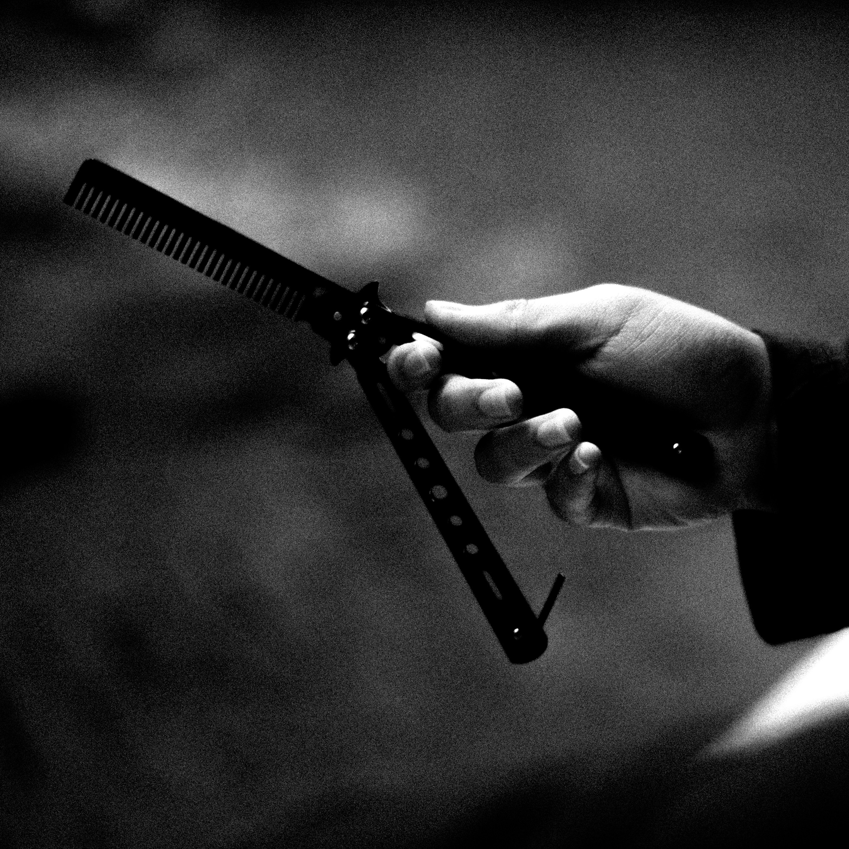 ein Schwarz-Weiß-Foto einer Person, die einen Kamm in der Hand hält