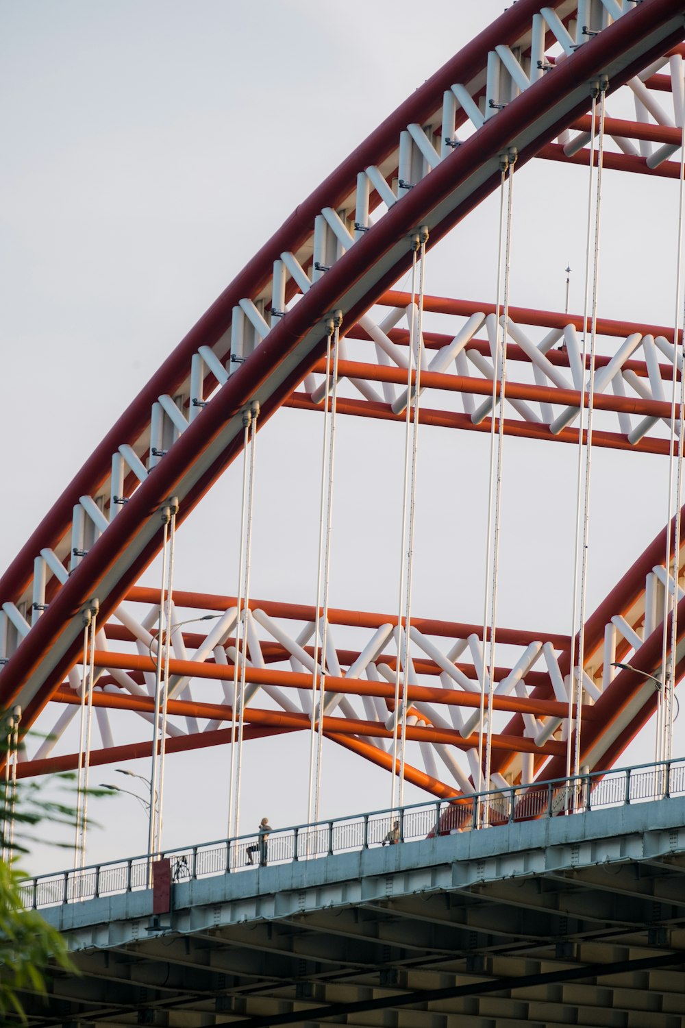 a roller coaster going over a bridge on a cloudy day