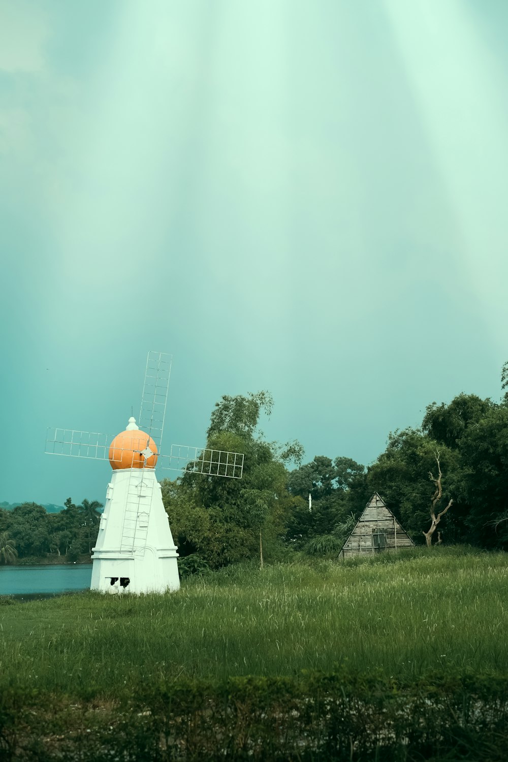 a windmill in the middle of a grassy field