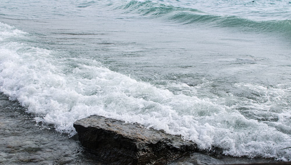 a rock sitting on top of a body of water