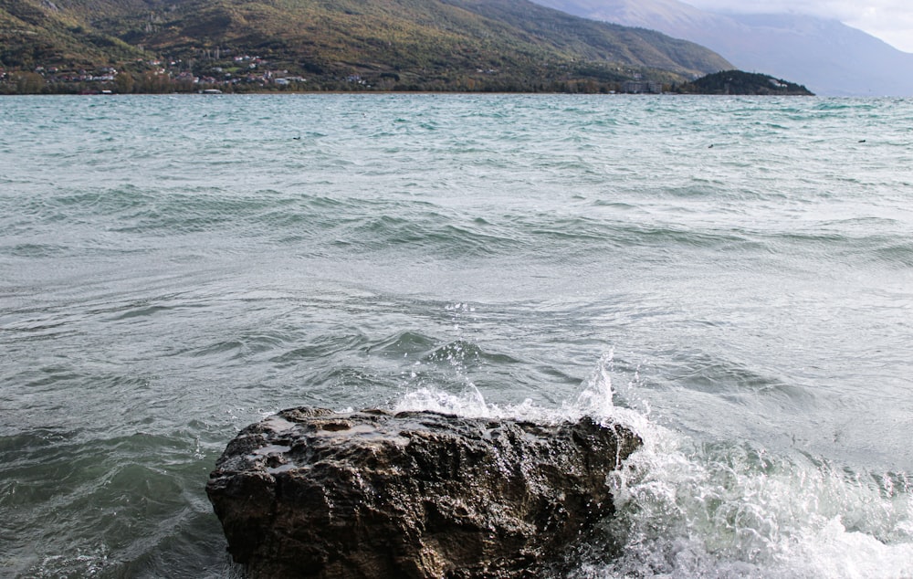 a large rock sticking out of the water