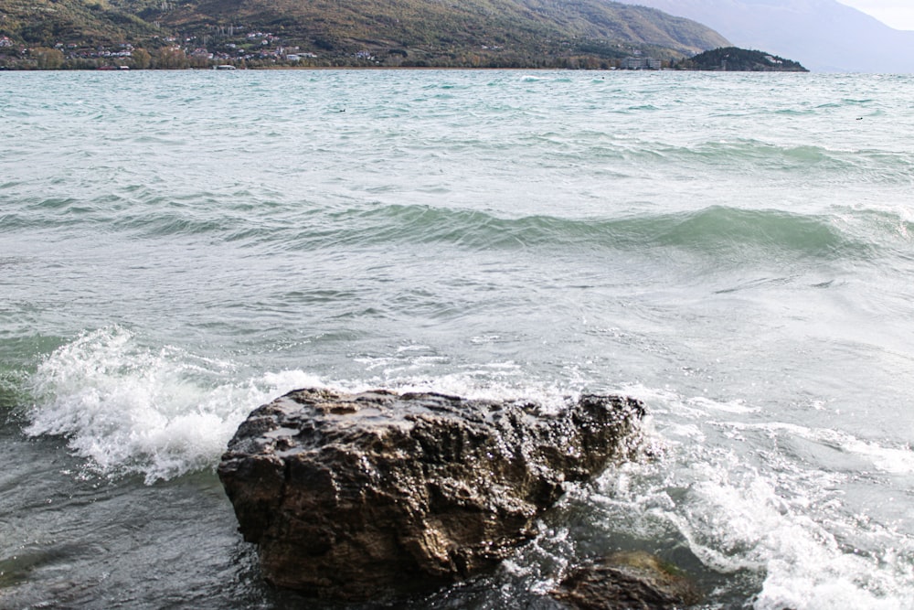 a large rock sitting on top of a body of water