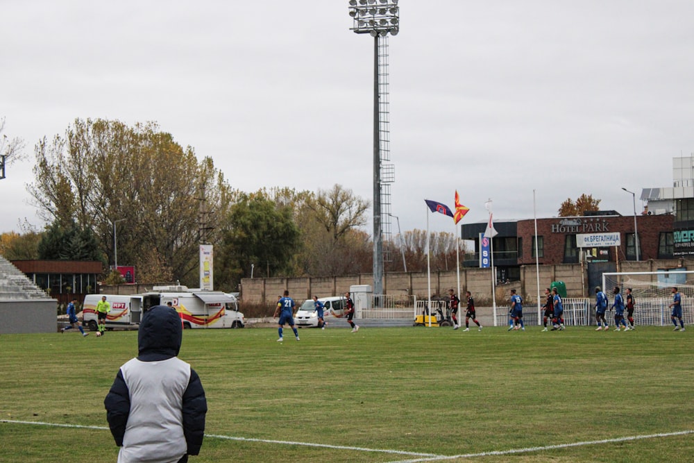 a group of people standing on top of a soccer field