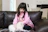 A cozy scene of a young woman cuddling her fluffy gray kitten on a cream-colored sofa