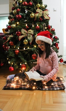 Children reading colorful Christmas books by a decorated fireplace.
