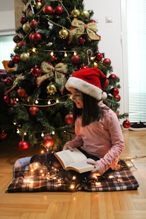 Children reading Christmas books together by a decorated fireplace.