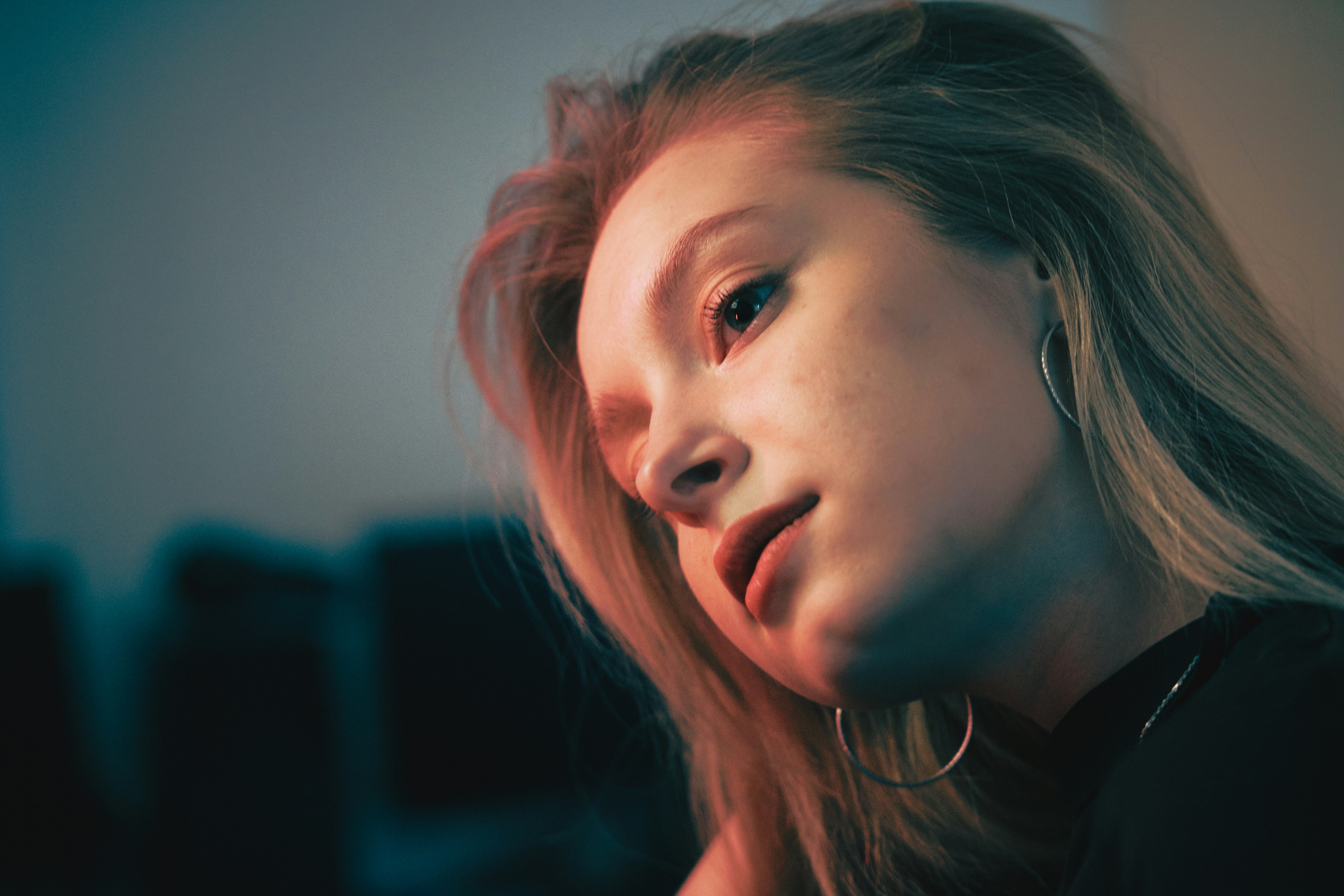 長いブロンドの髪とフープピアスの女性