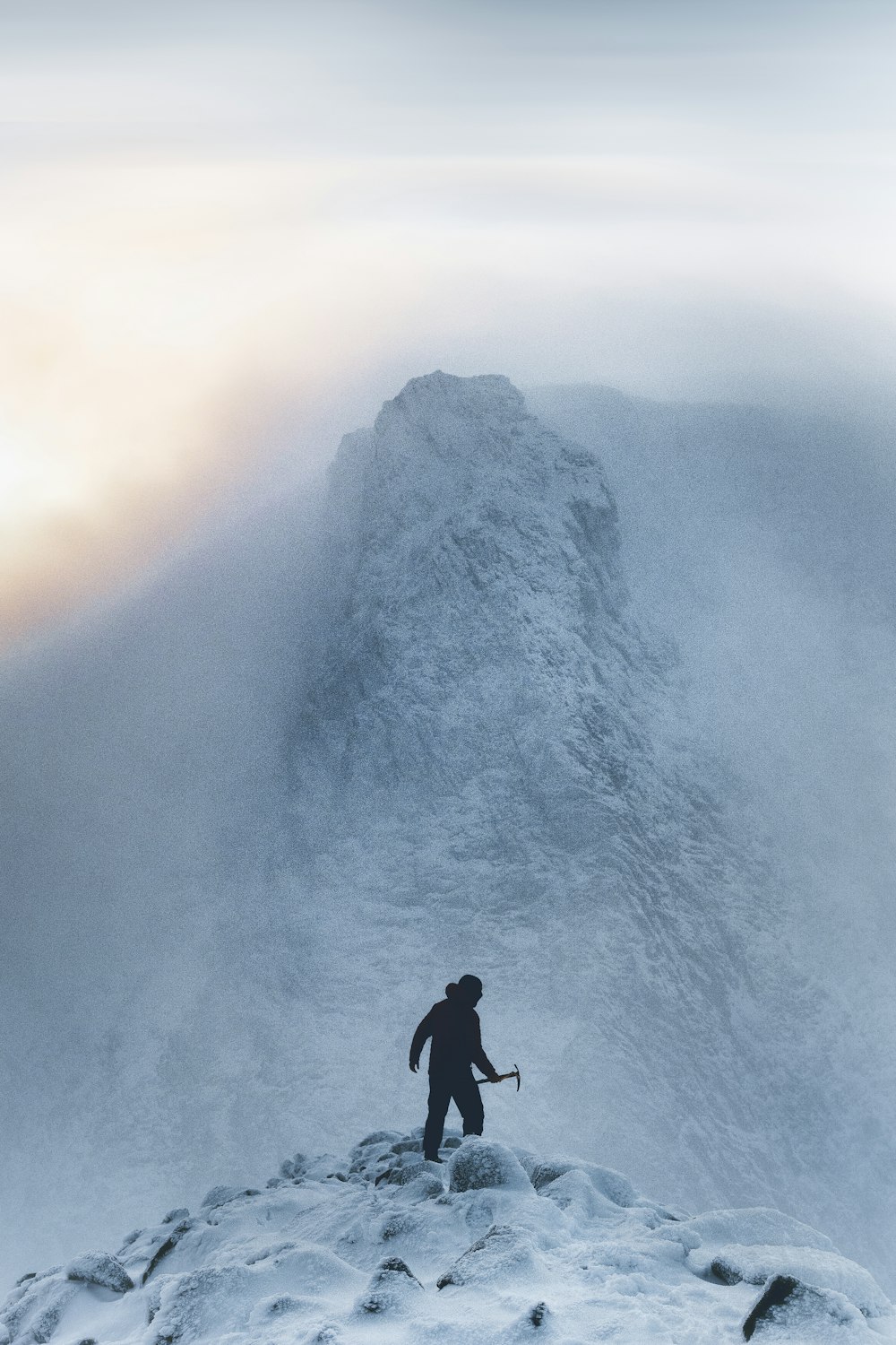 a man standing on top of a snow covered mountain