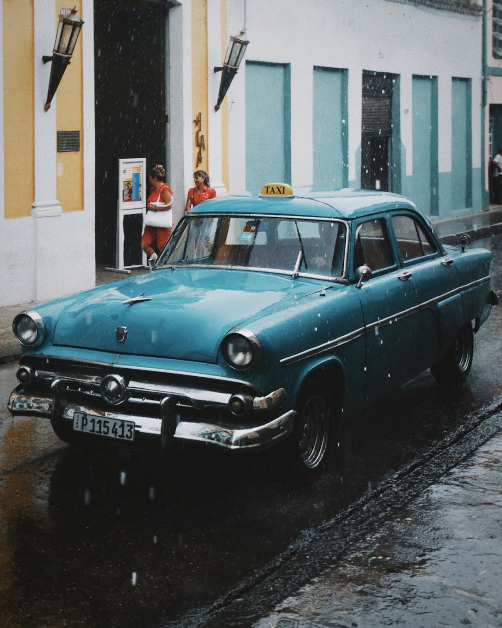 an old car is parked on the side of the road