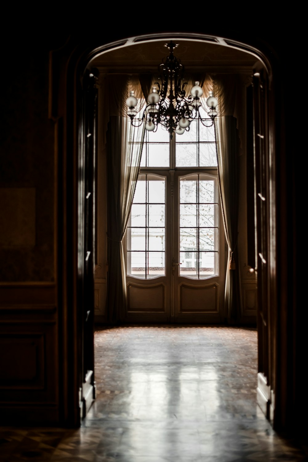 an open door with a chandelier hanging from it