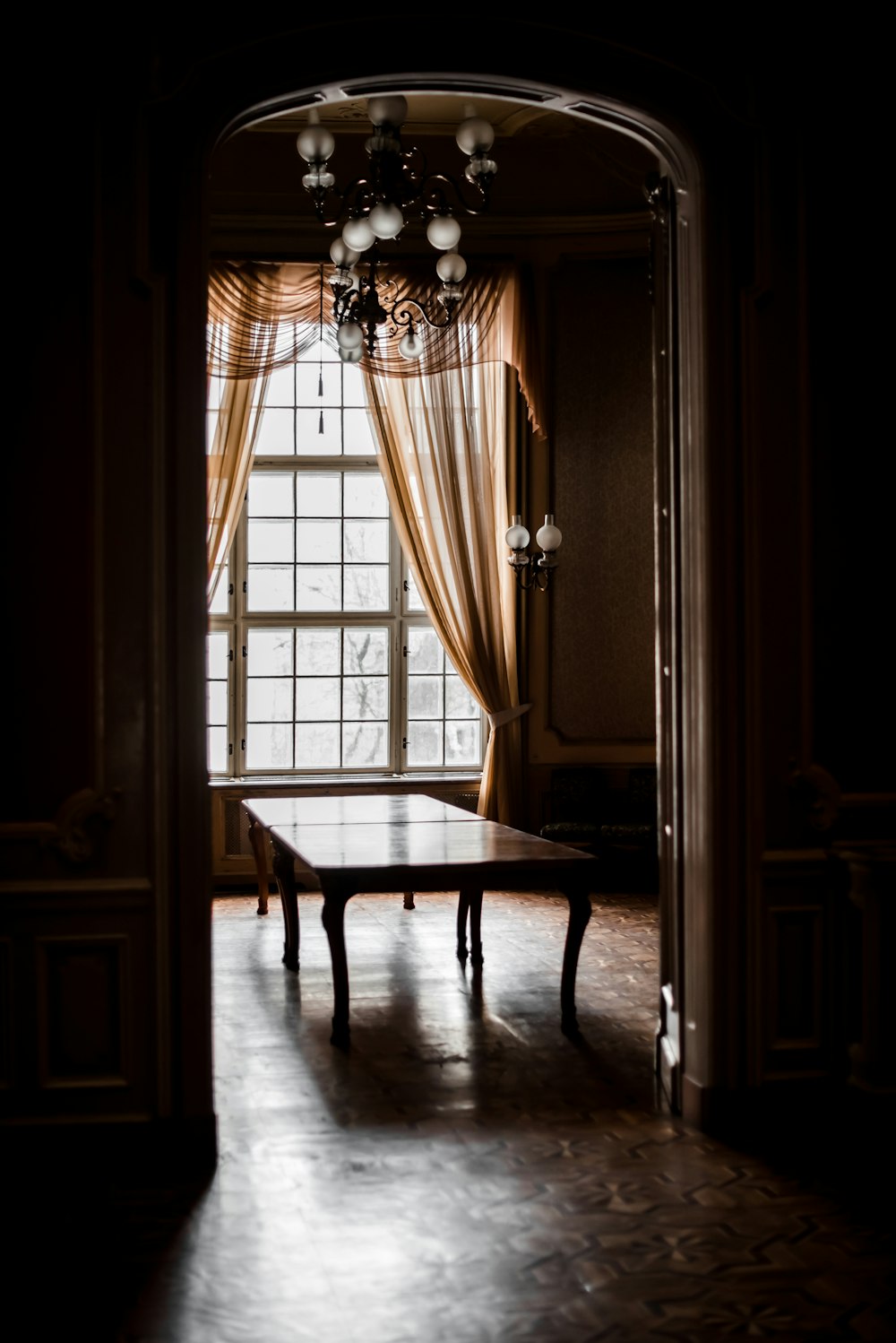 a room with a table and a chandelier in it