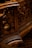 Intricate wooden carvings with swirling patterns, likely part of an ornate piece of furniture or architecture. The design showcases detailed craftsmanship with a focus on elegant curves and textures.