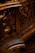 Intricate wooden carvings with swirling patterns, likely part of an ornate piece of furniture or architecture. The design showcases detailed craftsmanship with a focus on elegant curves and textures.