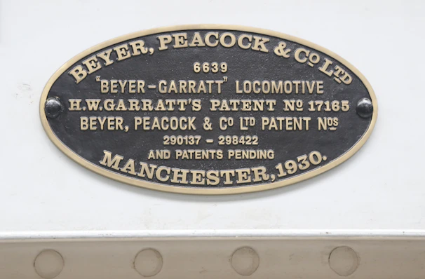 A detailed shot of a brass plaque on an early engine, highlighting the maker’s name and date of manufacture.