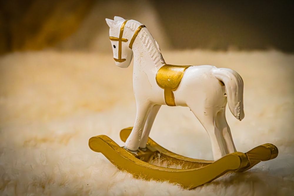 a toy rocking horse sitting on top of a white blanket