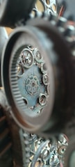 Intricate gears and cogs are interconnected and layered, creating a complex mechanical structure. The view is focused and detailed, showing various sizes of interlocking circular metal pieces.