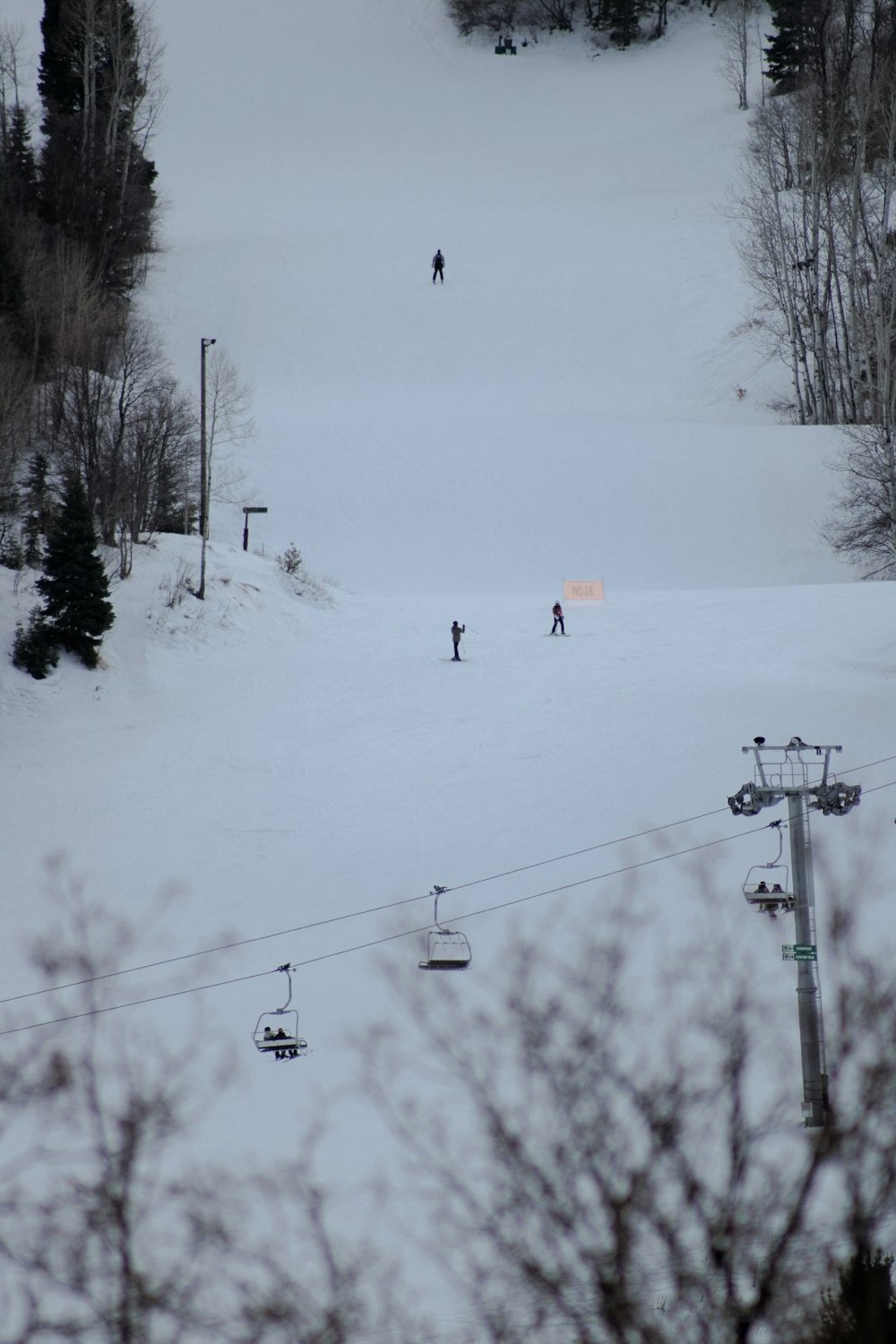 a couple of people riding skis down a snow covered slope