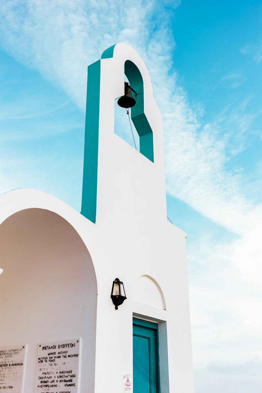 a white building with a blue door and a bell tower