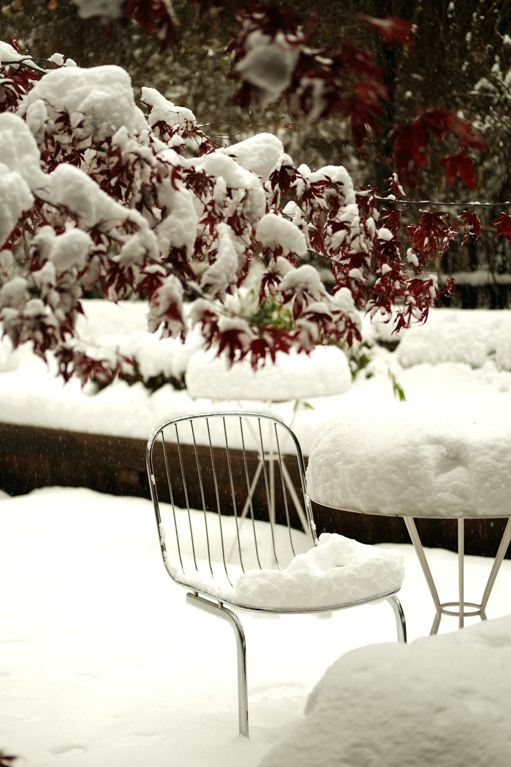 a white chair and table covered in snow