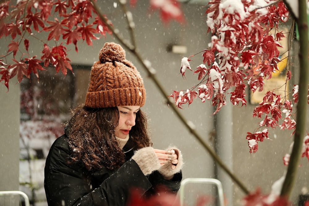 a woman in a brown hat is eating a hot dog