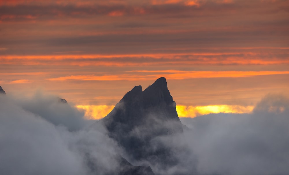 a view of a mountain with clouds in the foreground