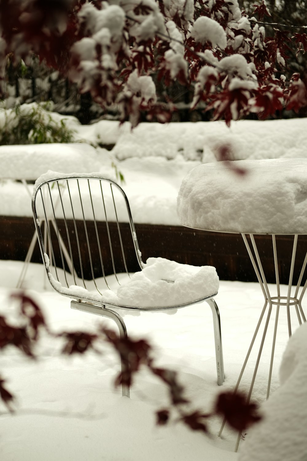 a couple of white chairs sitting on top of a snow covered ground