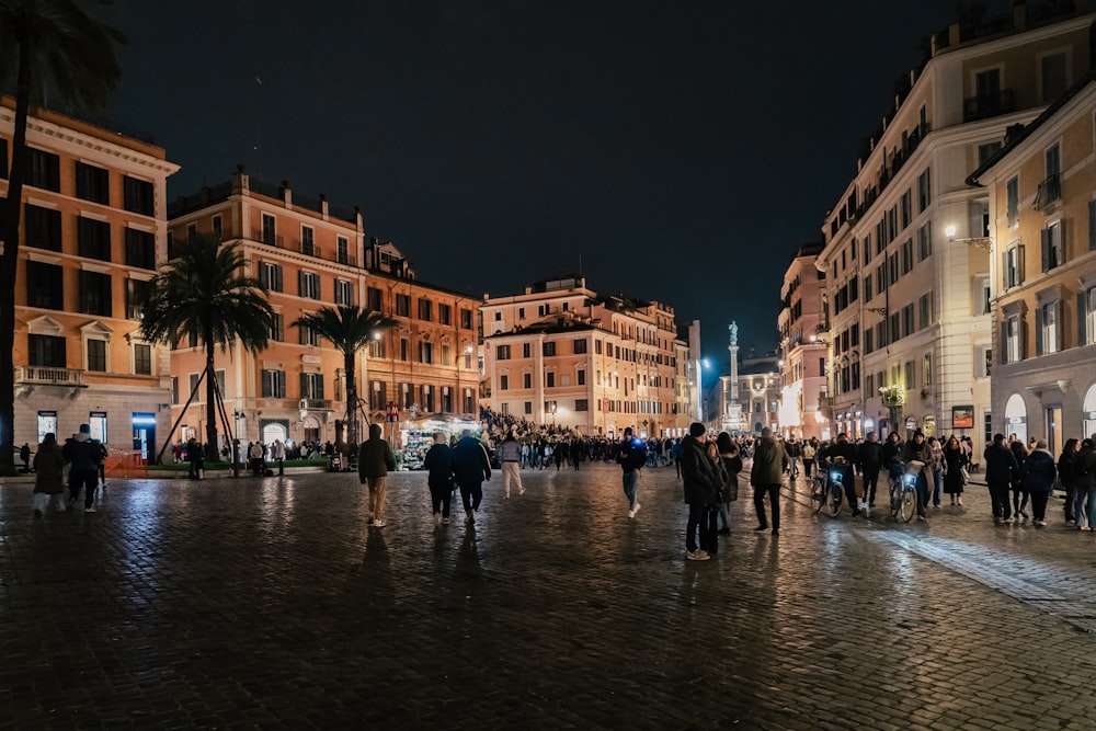 a group of people walking down a street at night