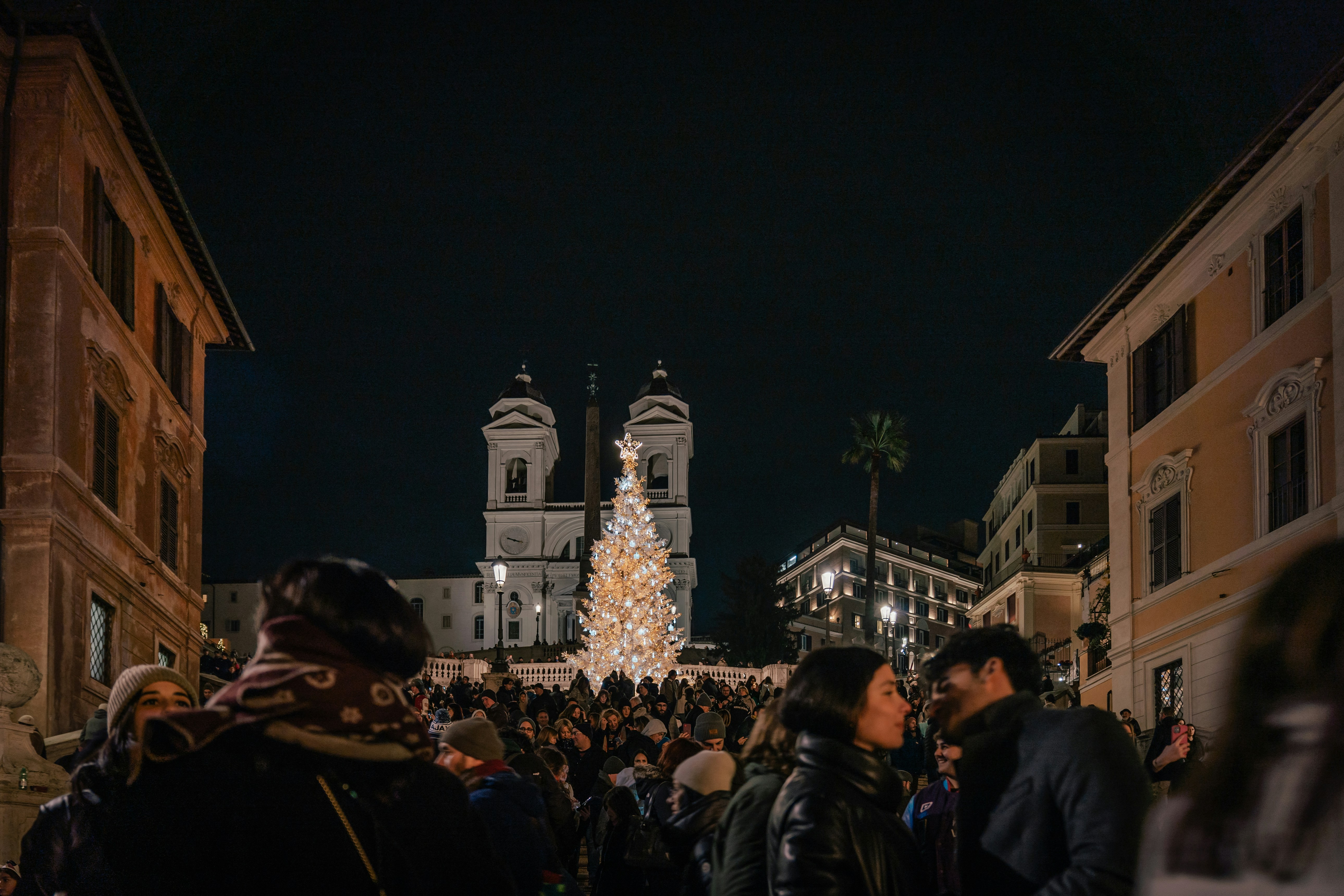 A crowd of people standing around a christmas tree photo – Free Rome ...