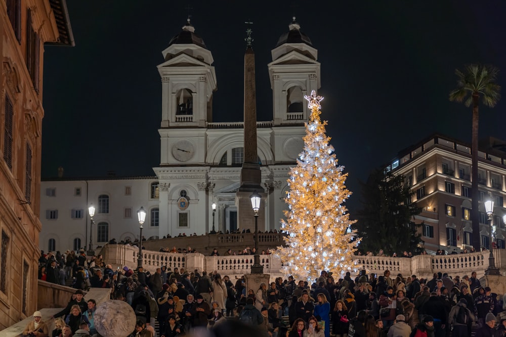 a large christmas tree in front of a church