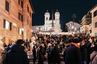a crowd of people standing around a building at night