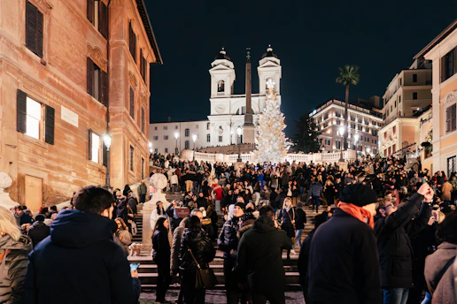 a crowd of people standing around a building at night