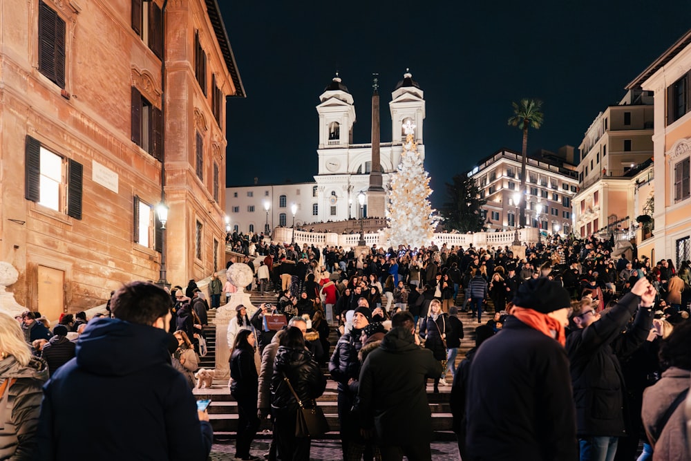 a crowd of people standing around a building at night