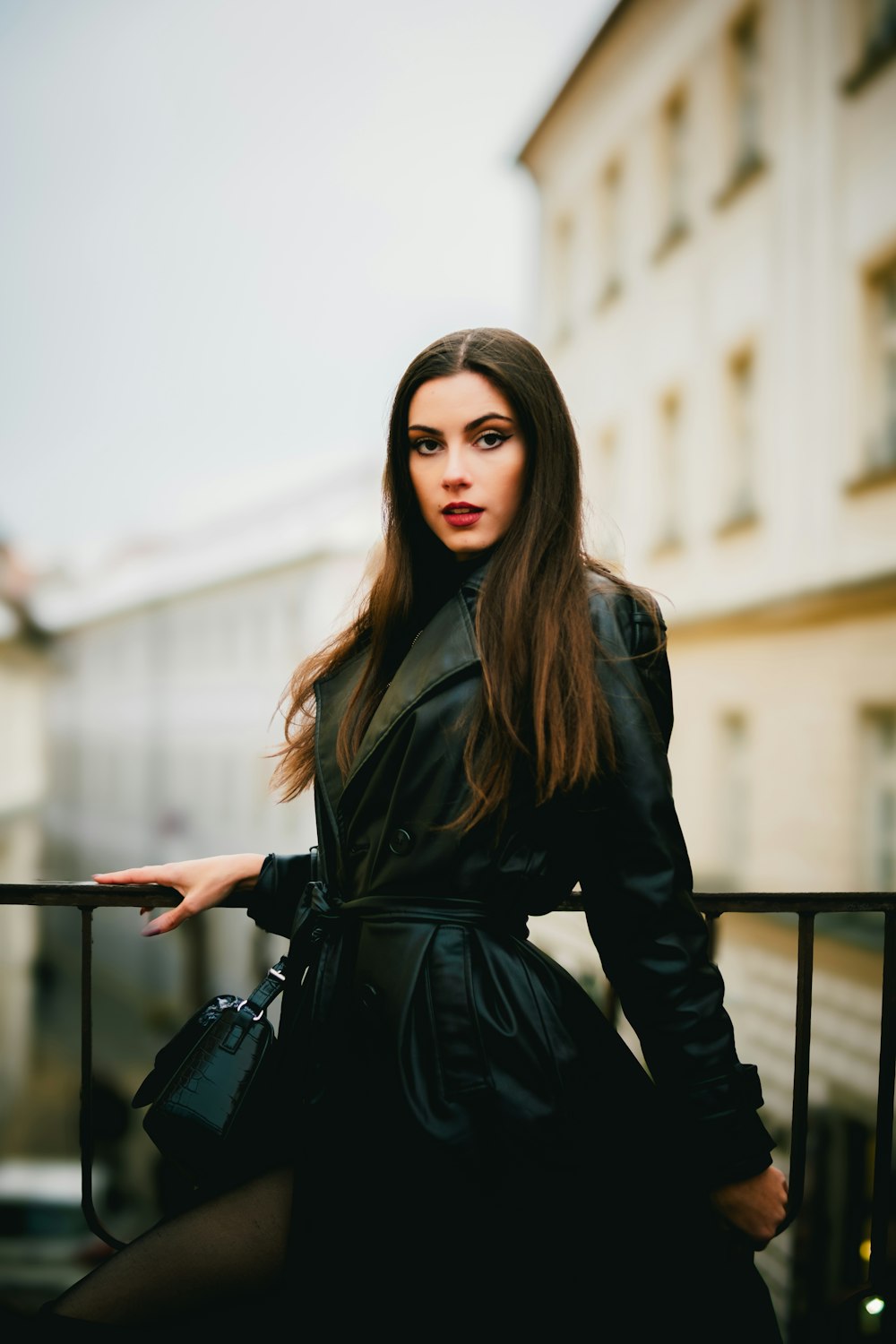 a woman in a black dress is standing on a balcony