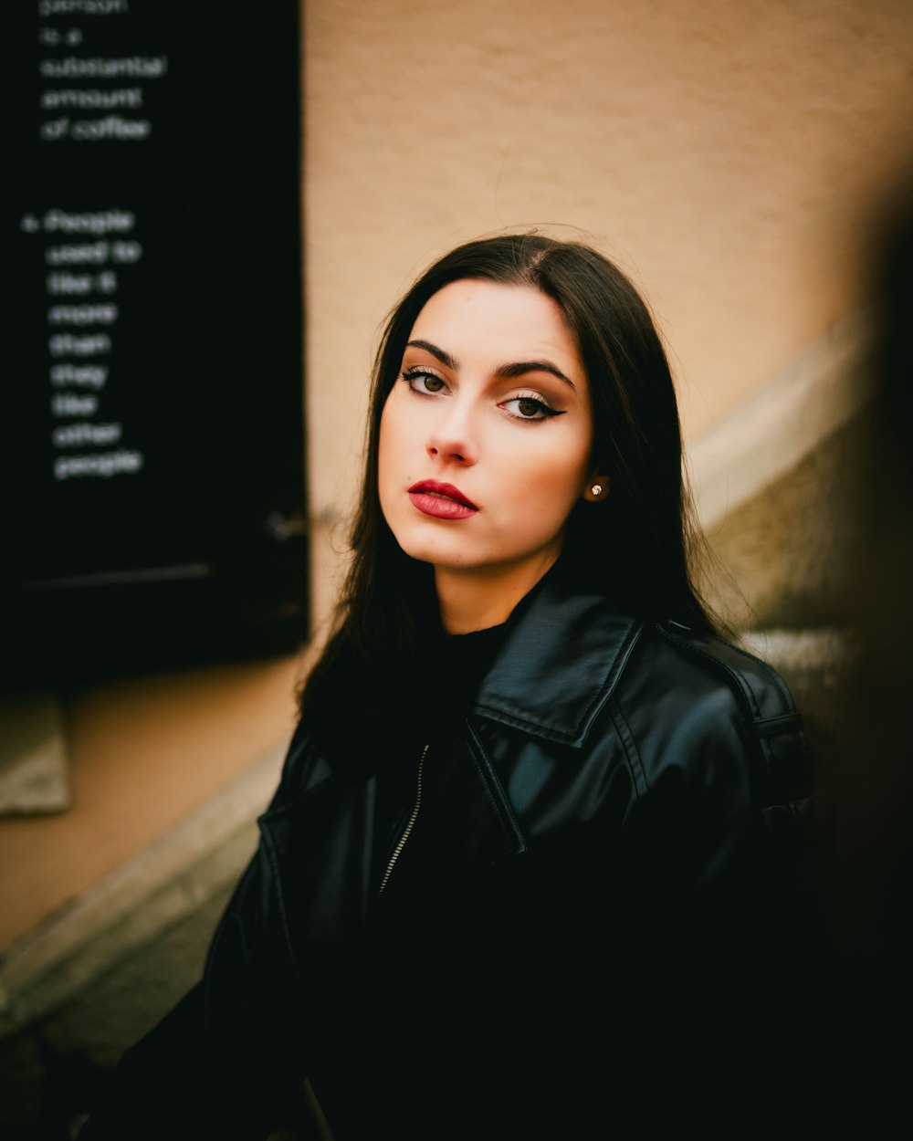 a woman in a black leather jacket posing for a picture