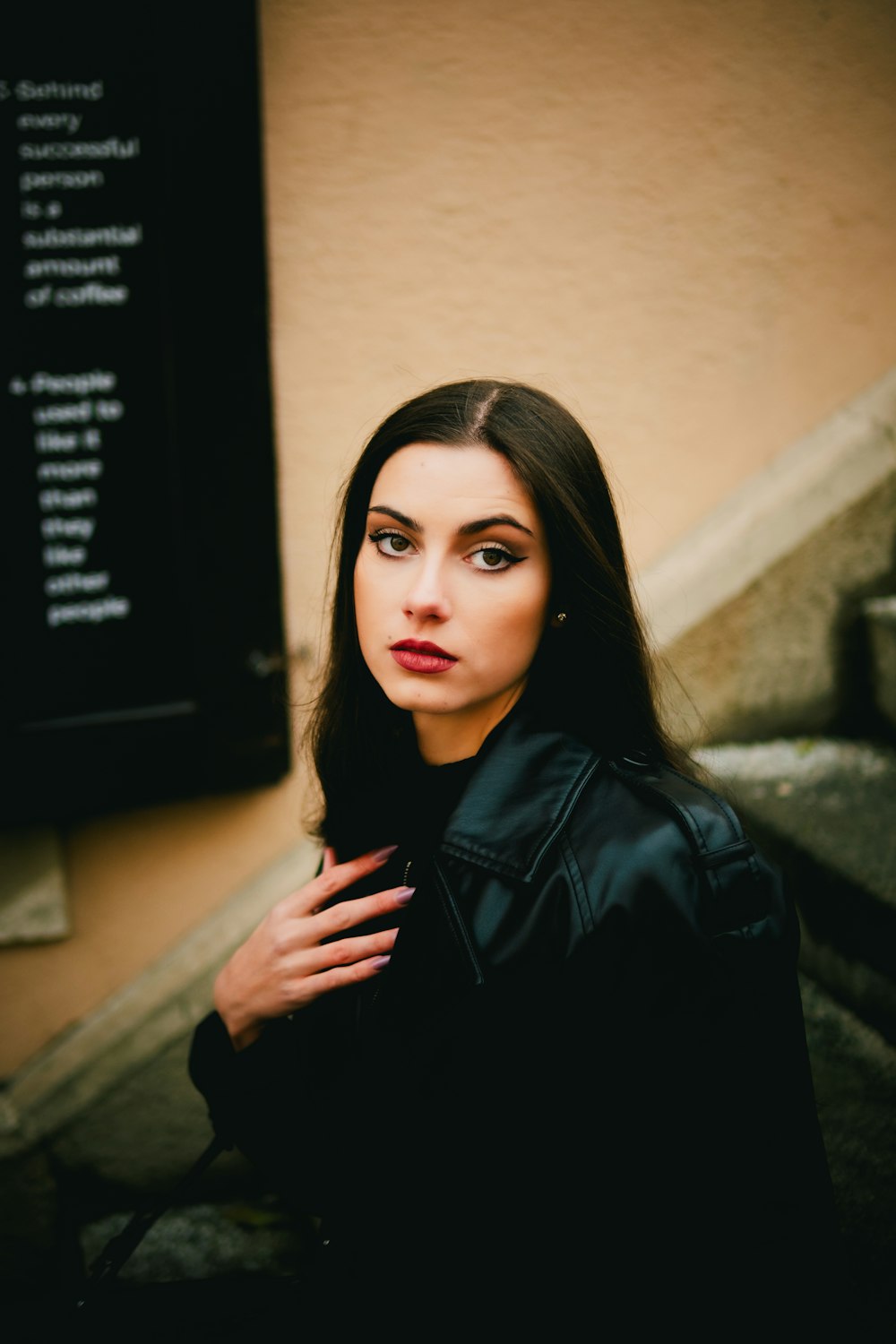 a woman in a black jacket is posing for a picture