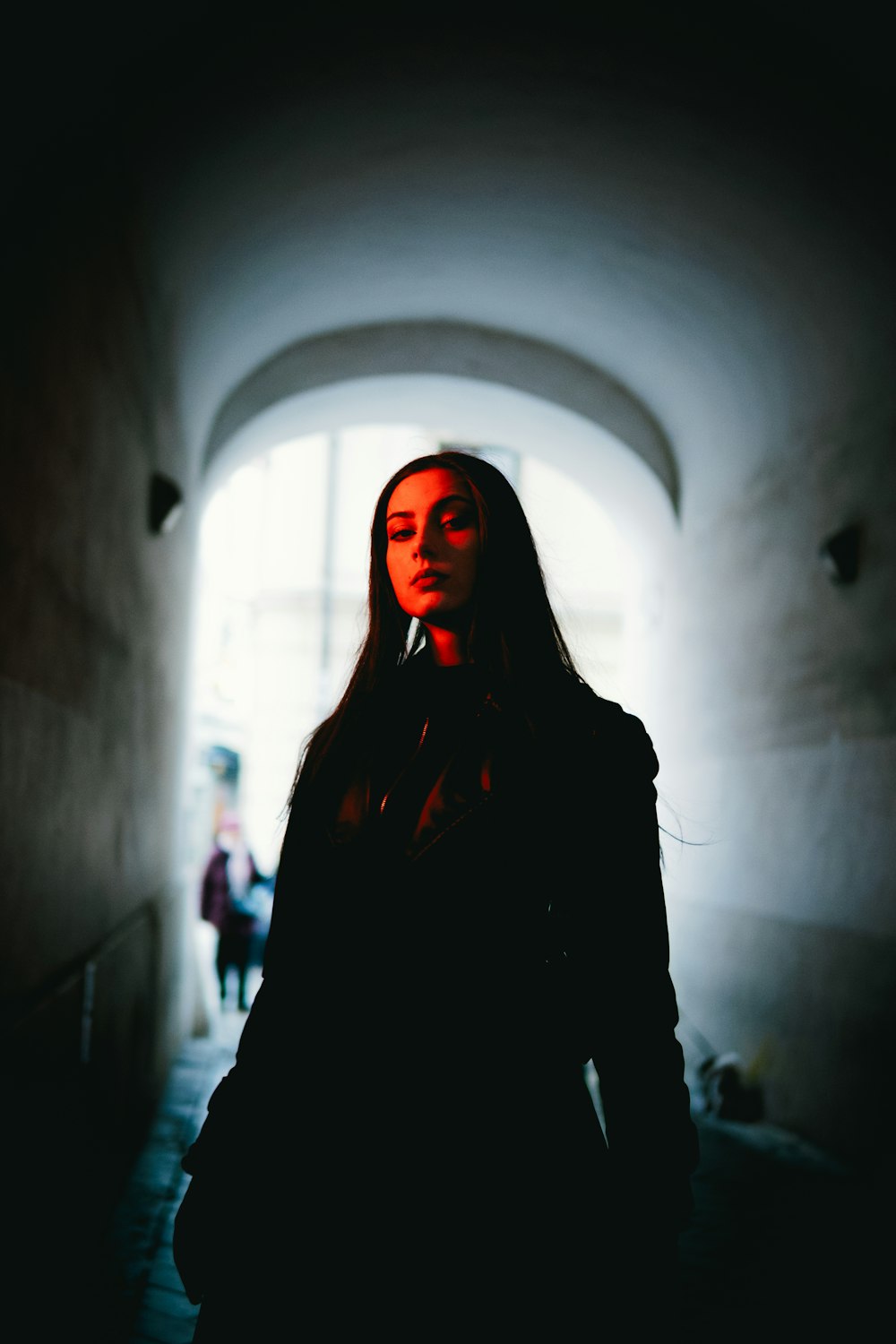 a woman standing in a dark tunnel with her eyes closed