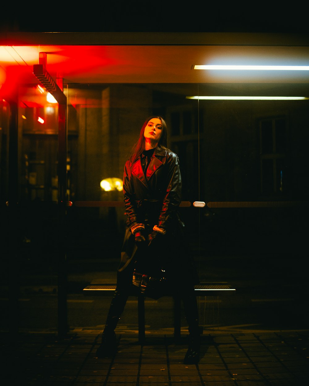 a woman sitting on a bench in the dark