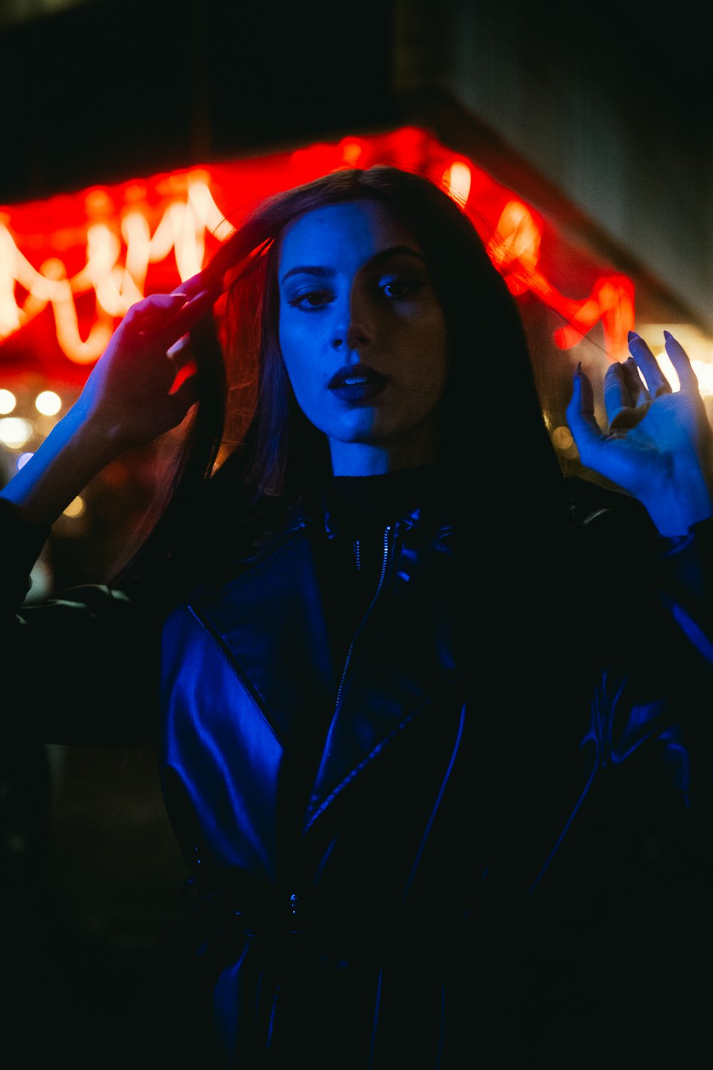 a woman standing in front of a neon sign