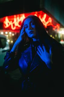 High-contrast shot of a black leather jacket illuminated by a single blue electric light from the side