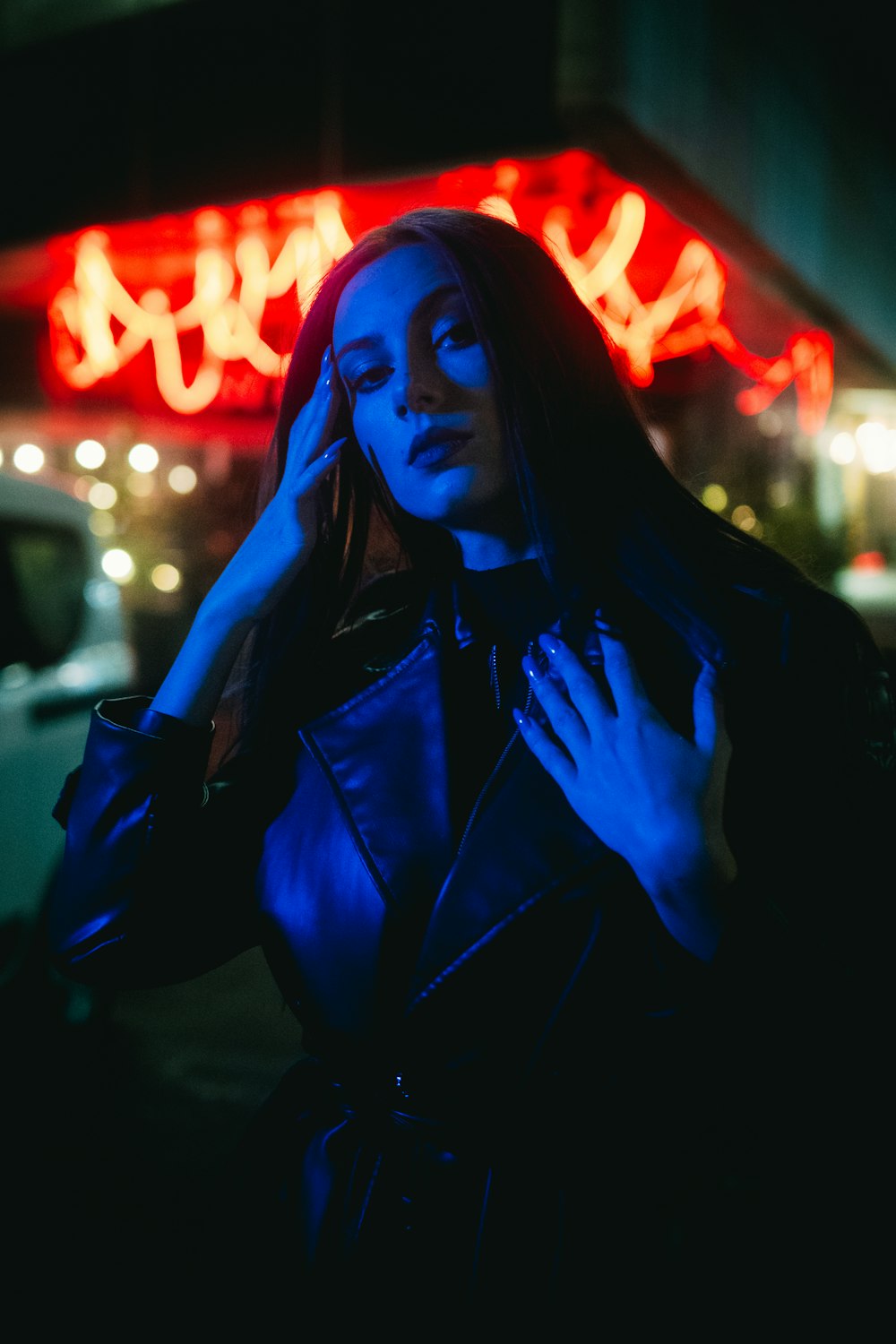 a woman standing in front of a neon sign