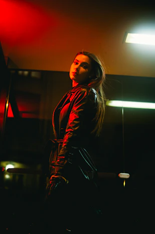 A moody, cinematic shot of a model wearing a vintage-inspired oversized jacket against a dark urban backdrop.