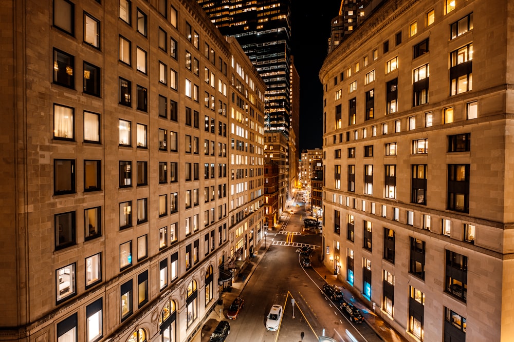 a city street at night with tall buildings