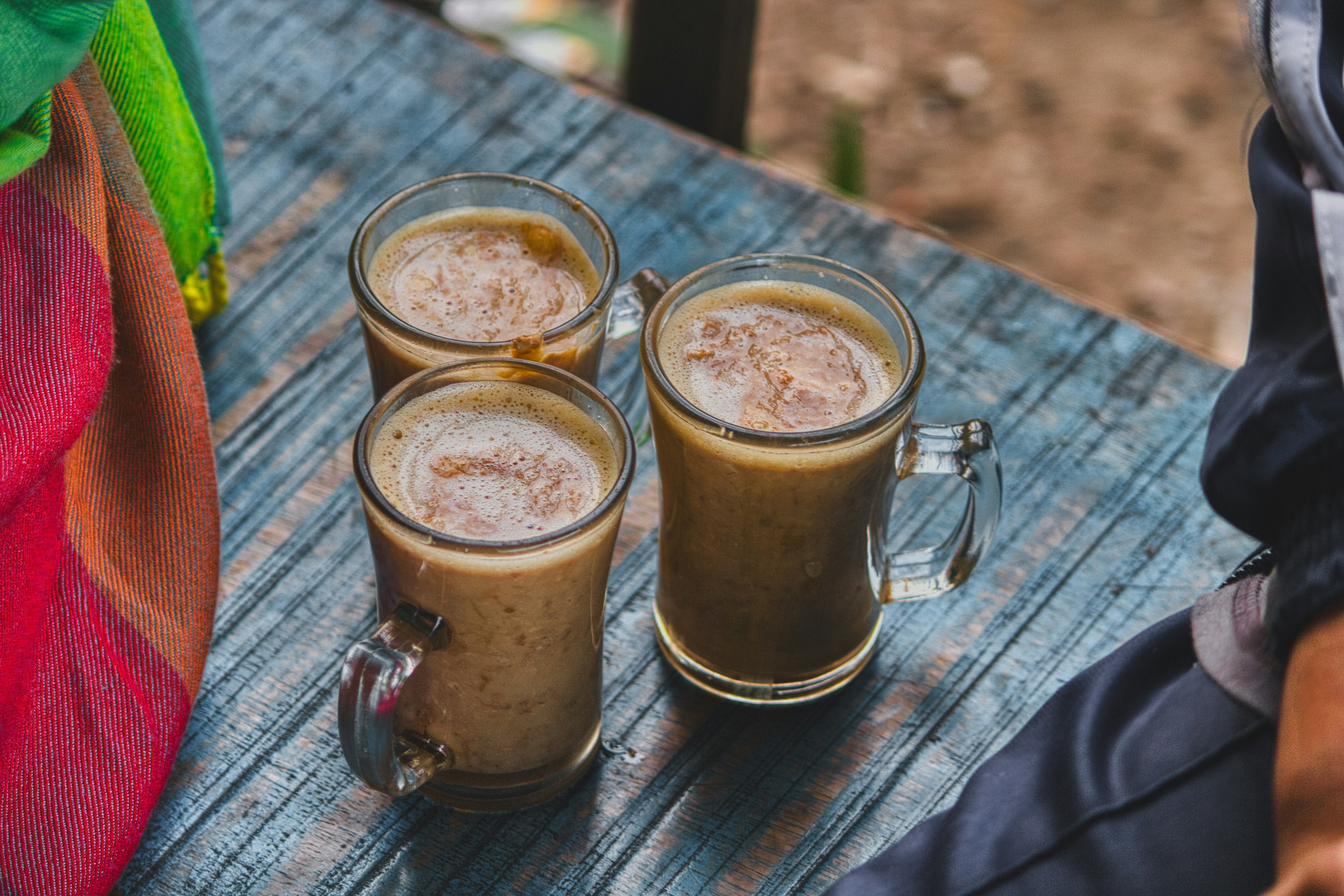 Two small glasses of milky coffee on a wooden table