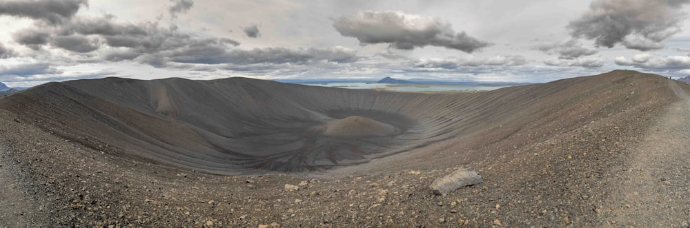 a panoramic view of a mountain with clouds in the sky